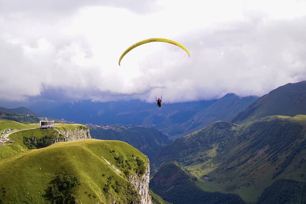 Paraglider flying above the mountains of Gudauri, Georgia